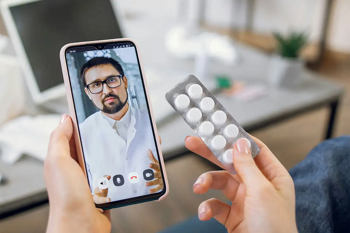 Individual presenting a tablet with pills, illustrating the benefits of virtual mental health treatment options